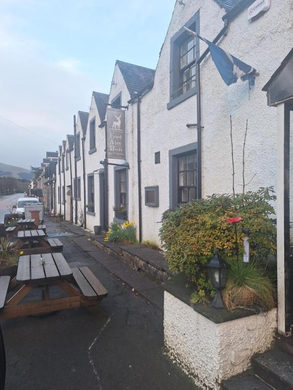 a row of tables and benches in front of a building at The Inn at Strathyre in Strathyre