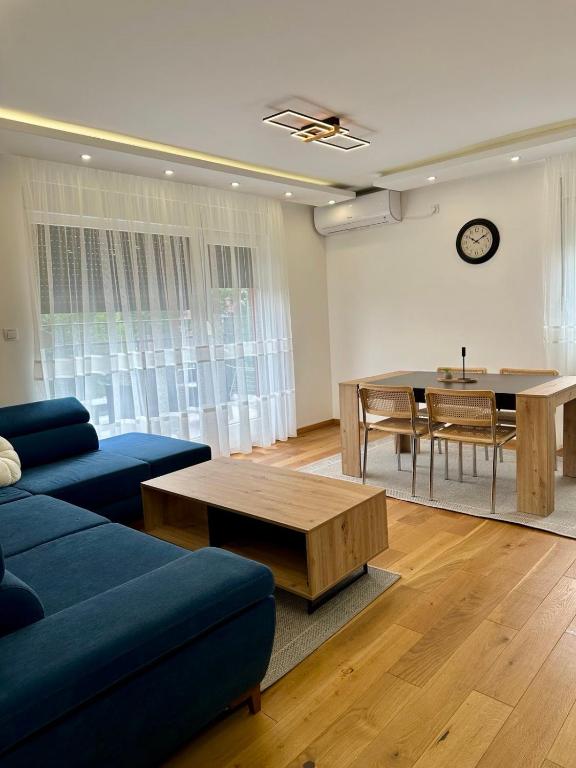 a living room with a blue couch and a table at VIP House 5 in Vrnjačka Banja