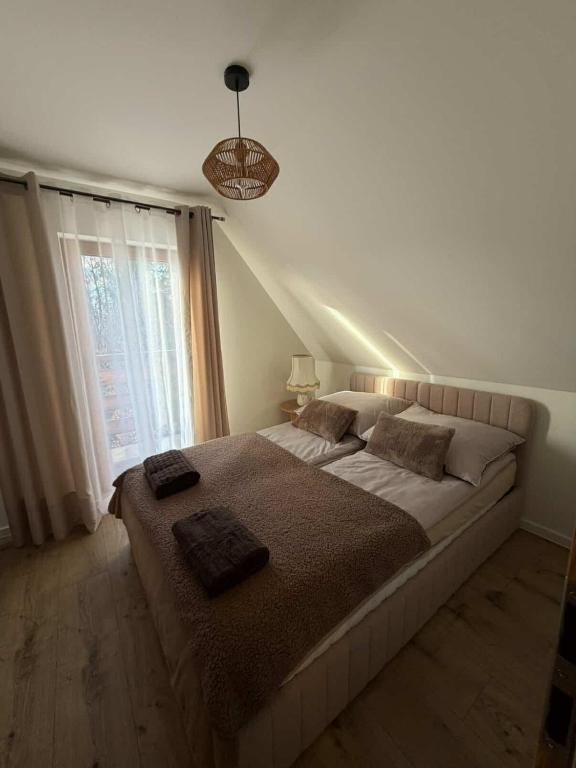 a bedroom with a large bed with two pillows on it at Domek u Łowiszów in Dzianisz