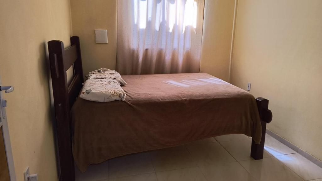 a small bed in a room with a window at Kitnet Praia de Alagoinhas in Fortaleza