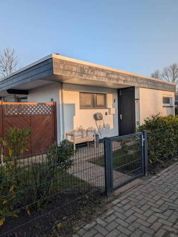 a small house with a fence in front of it at Ferienhaus LouJa in Butjadingen