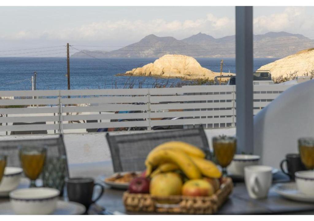 a table with a basket of fruit on top of it at Stella's Mandrakia Seaside House in Mandrakia