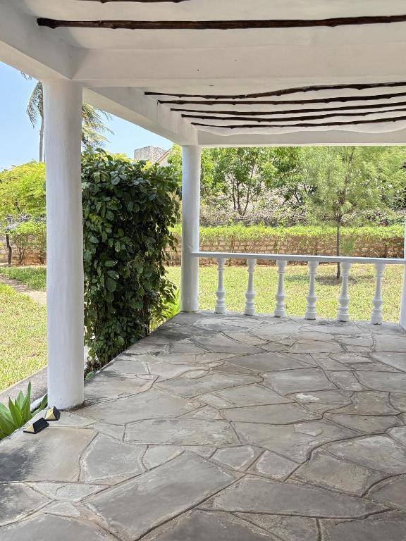 a white porch with a stone patio at Mango House Watamu in Watamu
