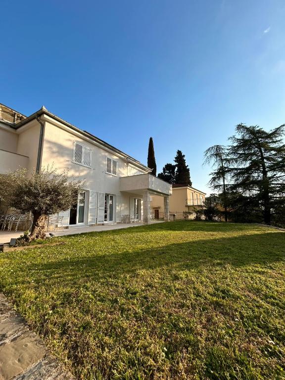 a large white house with a large yard at Porto MarIn Strašek in Portorož