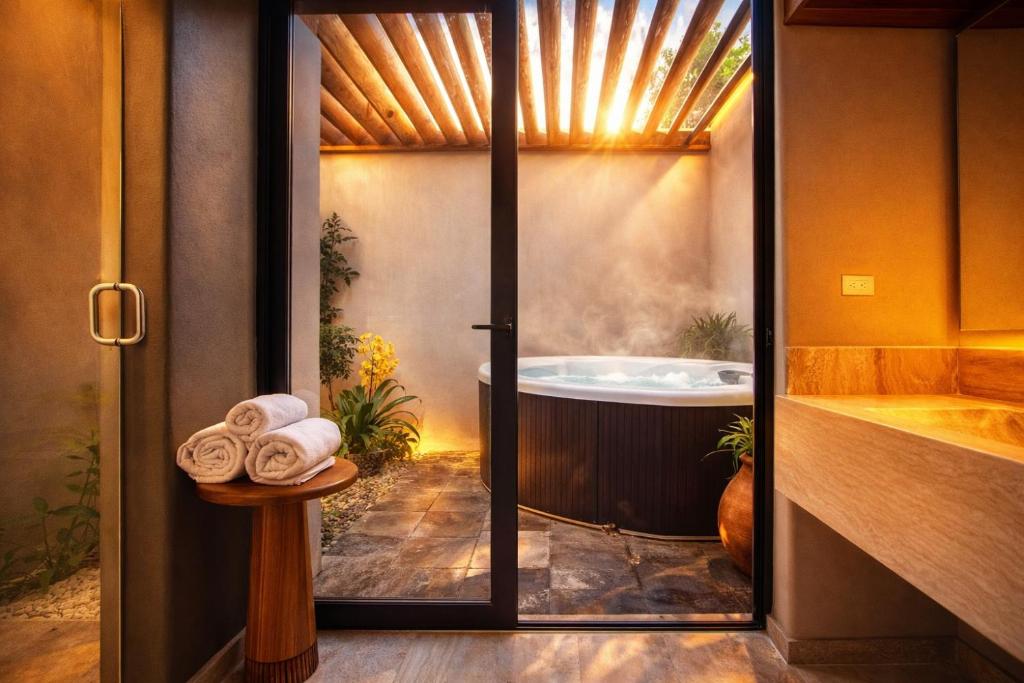 a bathroom with a bath tub and a shower at Hotel Flores de Sal-Valle de Guadalupe in Valle de Guadalupe