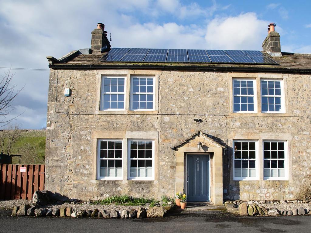 a stone house with solar panels on the roof at Kirk Yett in Skipton