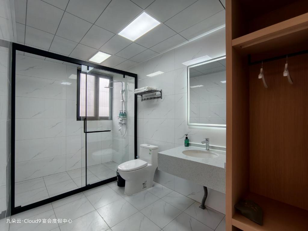 a bathroom with a shower and a toilet and a sink at Cloud 9 Resort Hotel in Yangchang