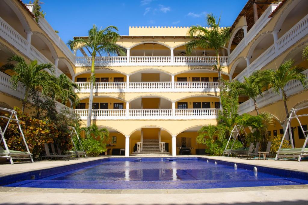 an exterior view of a building with a swimming pool at We playa Hotel - Adults Only in Playa del Carmen