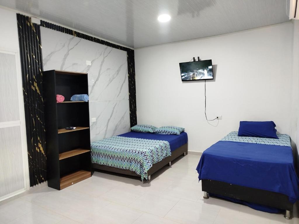 a bedroom with two beds and a tv in it at Apartaestudio Marbella #2-10 in Cartagena de Indias