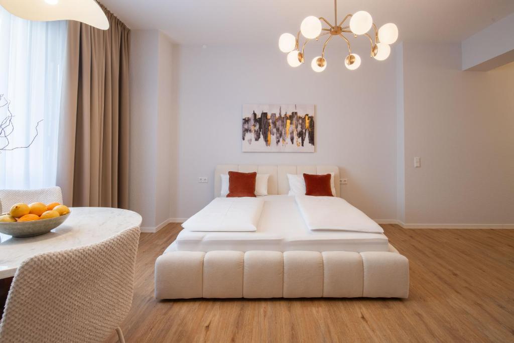 a bedroom with a large white bed and a table at Altstadt City Loft in Würzburg