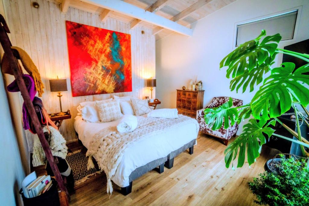 a bedroom with a bed and a painting on the wall at Hau Lodge Malalcahuello Corralco Starlink in Malalcahuello