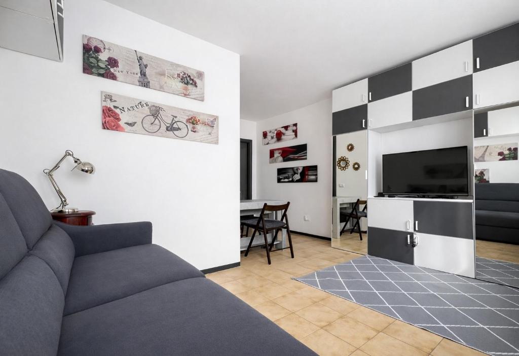 a living room with a couch and a television at Bella Vita Stays Cozy in Sondrio