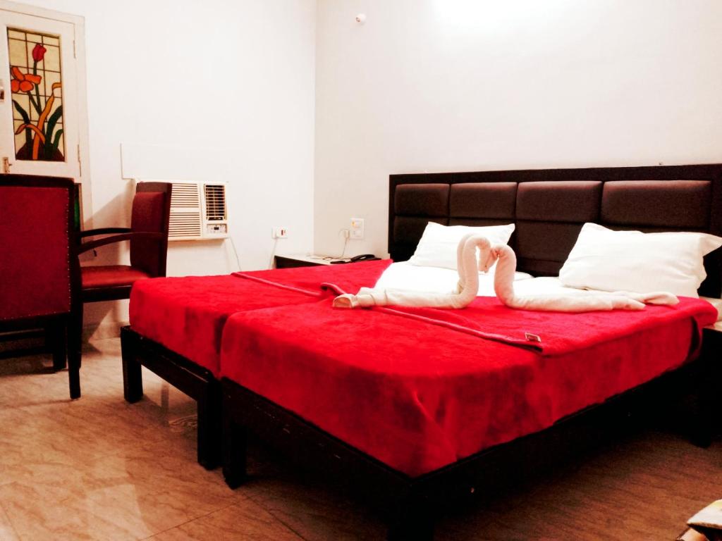 a bedroom with a bed with two swans laying on it at Hotel Sanskar in Pachmarhī