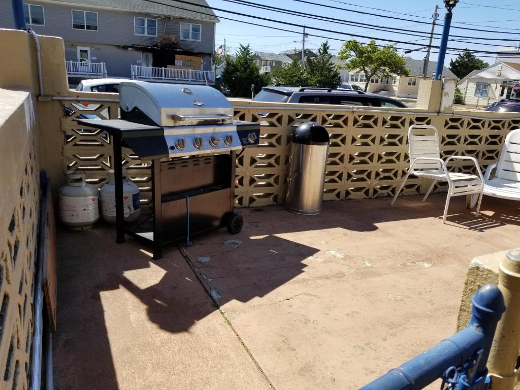 a grill sitting on a patio next to a fence at Atlantic Inn Seaside Heights in Seaside Heights