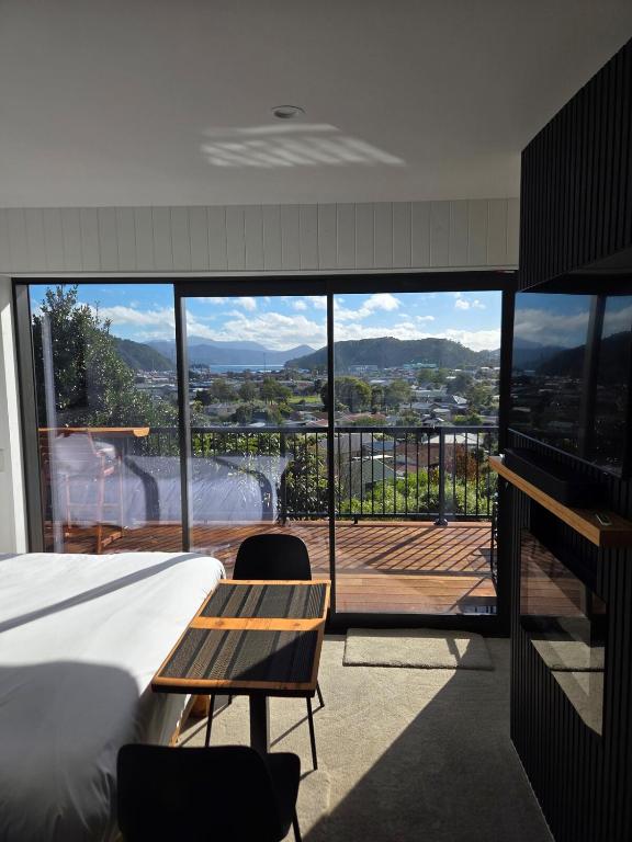 a bedroom with a bed and a balcony with a view at The Landing - Picton in Picton