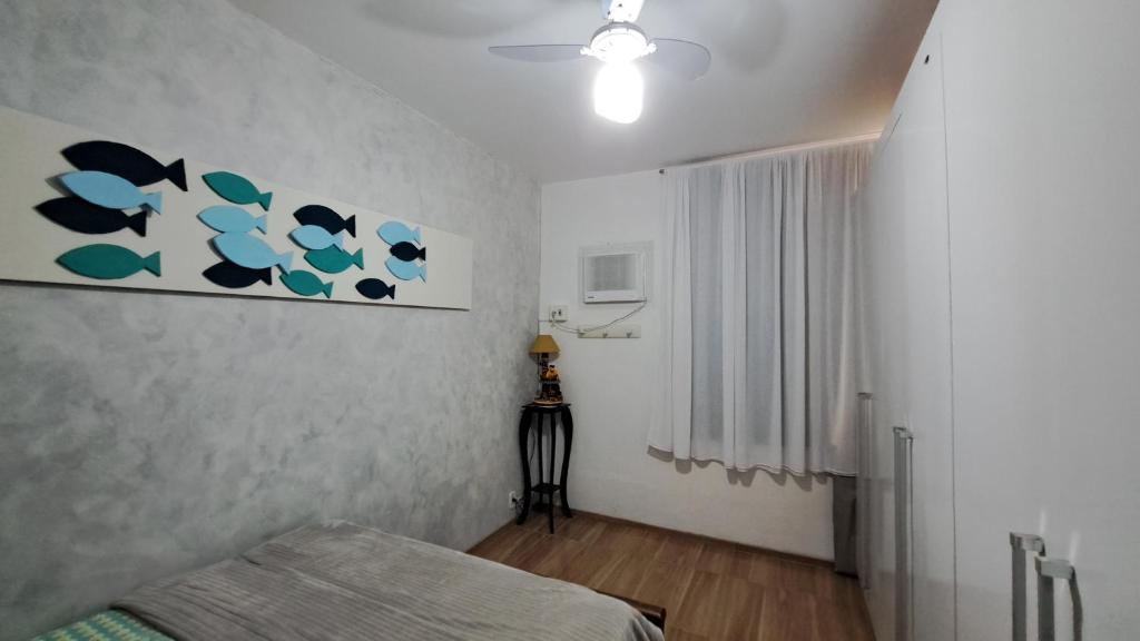 a bedroom with a bed and a painting on the wall at Quarto da Orla in Cabo Frio