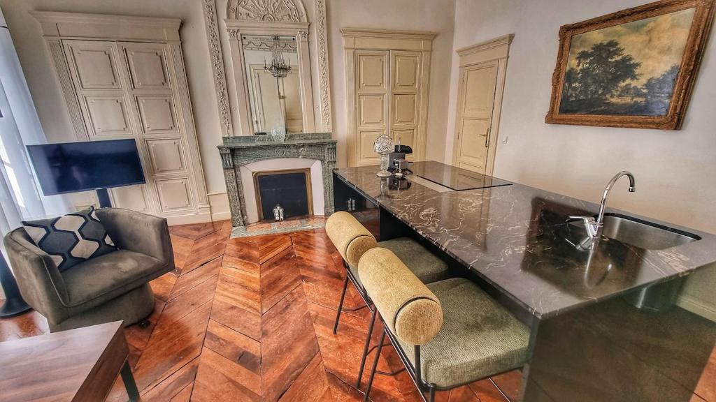 a living room with a counter and a fireplace at App T2 avec piscine chauffée in Luchon