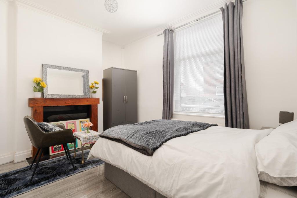 a bedroom with a bed and a chair and a fireplace at Modern 3-Bedroom Home in-Steps from Crown Point in Denton