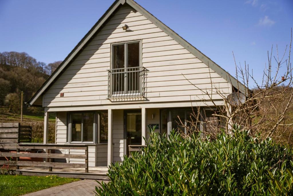 a white house with a window and a balcony at Maple Lodge in Knighton