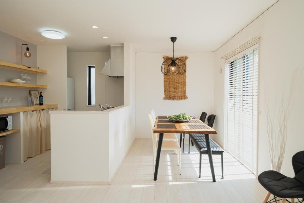 a kitchen and dining room with a table and chairs at Guesthouse tontonmie in Gimbaru