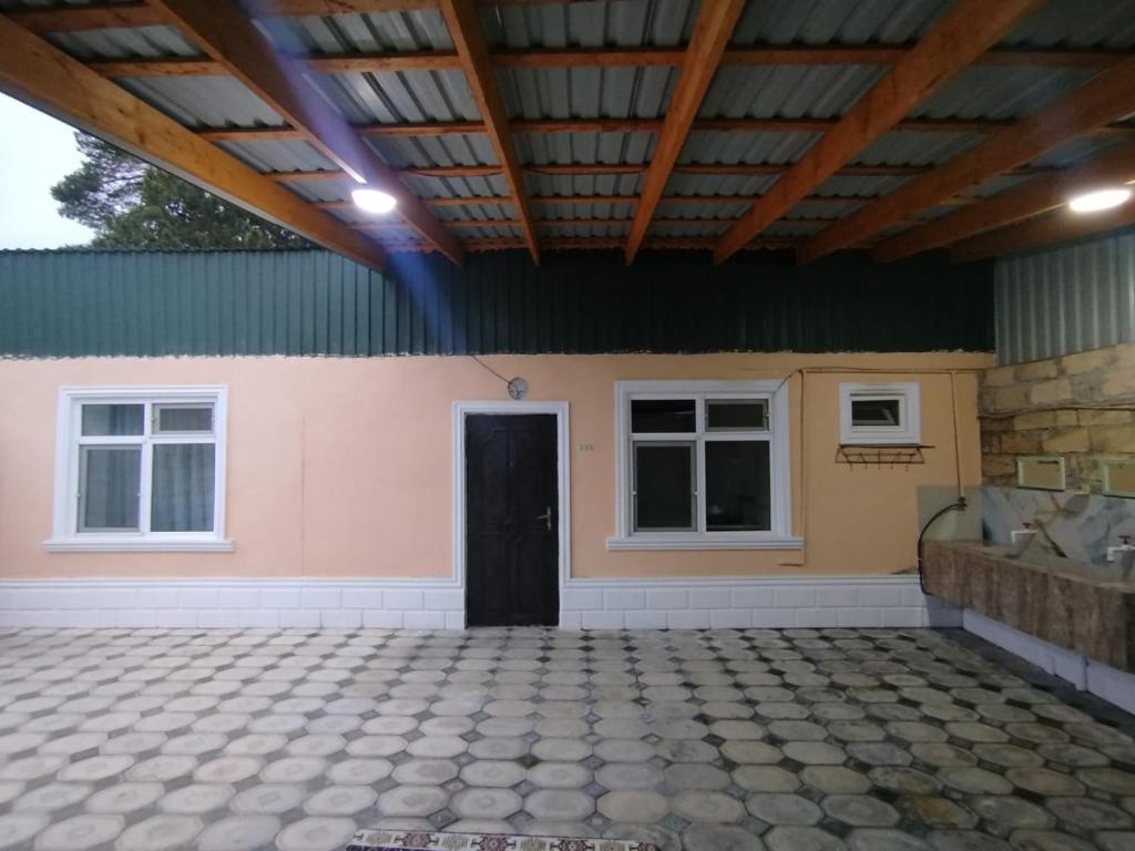 a room with a black door and two windows at Rest House in Quba