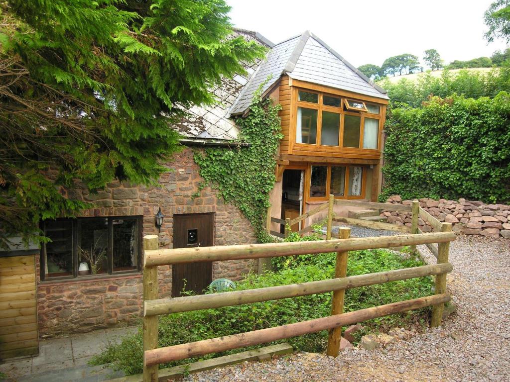 a house with a wooden fence in front of it at Selworthy- Ukc4915 in Timberscombe