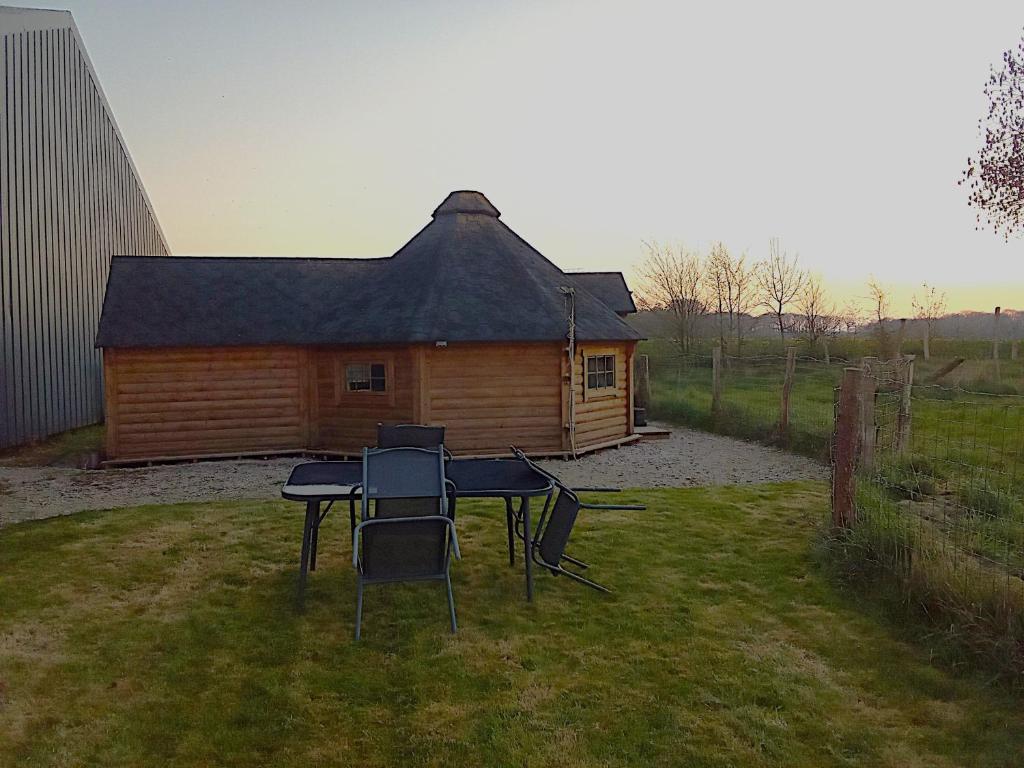 a group of chairs sitting in front of a cabin at kota en Normandie in Couvains
