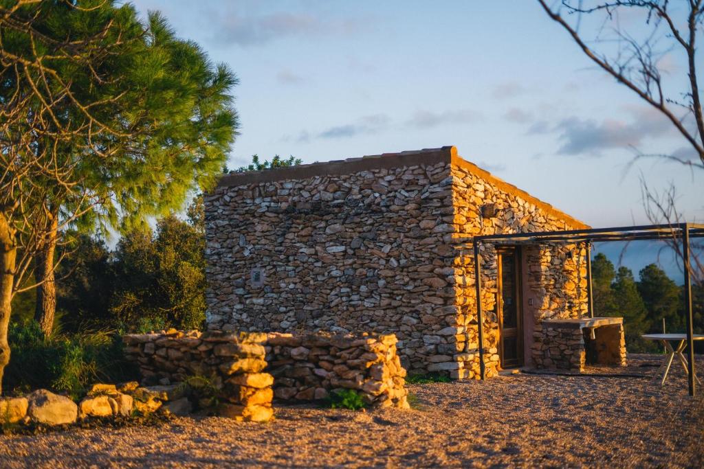 a stone house with a stone wall at Habitació EL GRANER in Rasquera