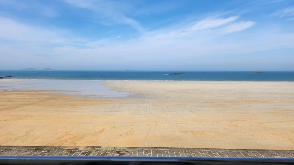 a view of a beach with the ocean in the background at Chambre avec vue sur mer in Saint Malo