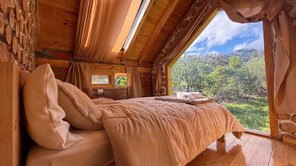 a bedroom with a bed and a large window at El Tiklan Glamping in Chucchilán