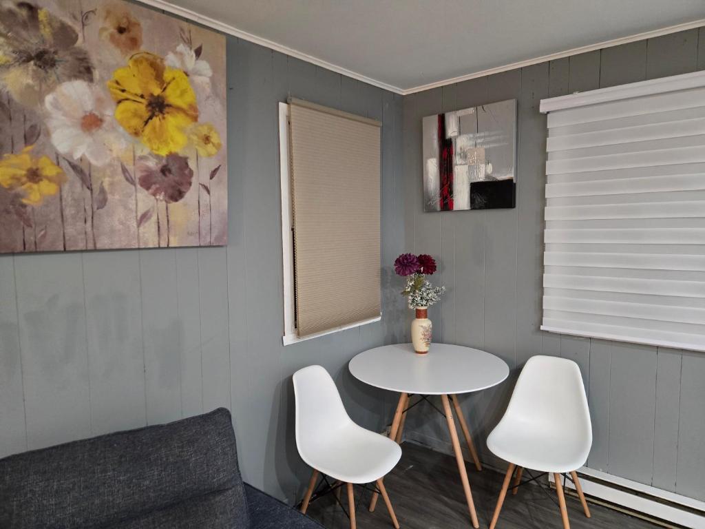 a living room with a table and two white chairs at Brossard home in Brossard