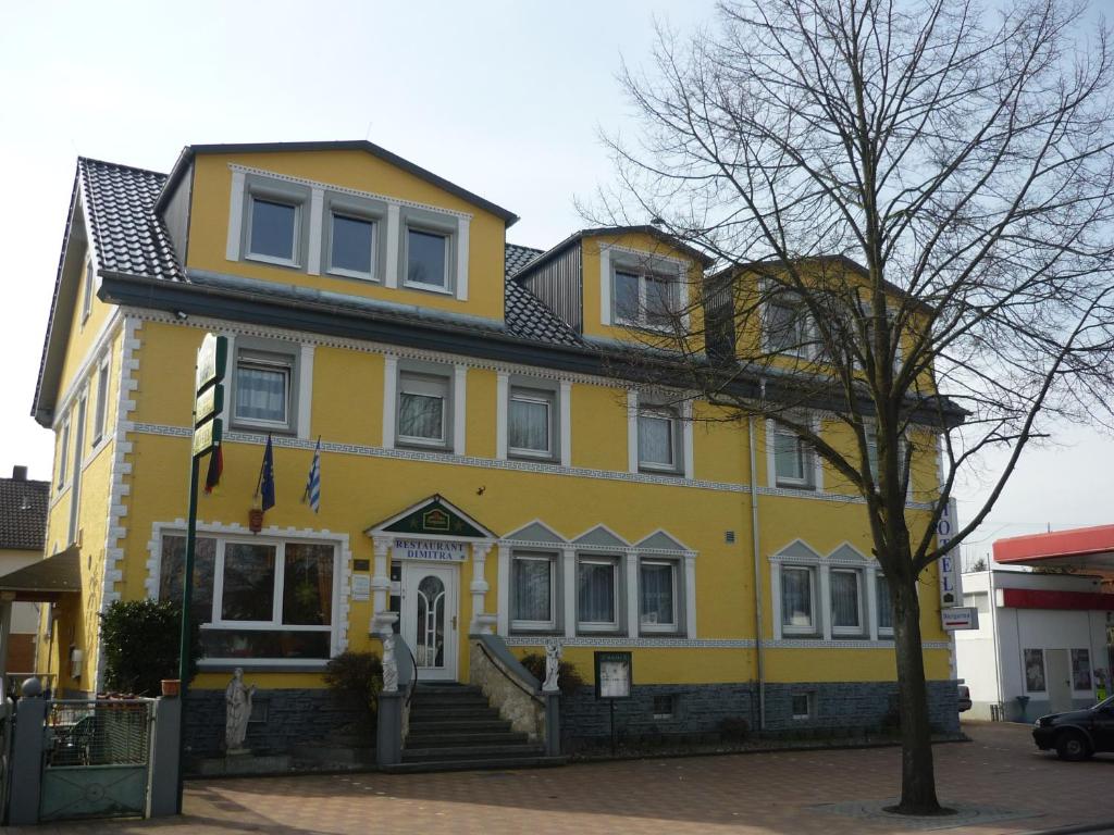 a yellow house with a black roof at Restaurant-Hotel Dimitra in Alsbach-Hähnlein