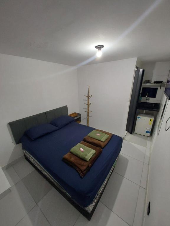 a bedroom with a blue bed in a white room at Pousada Caverna da Praia in Rio de Janeiro