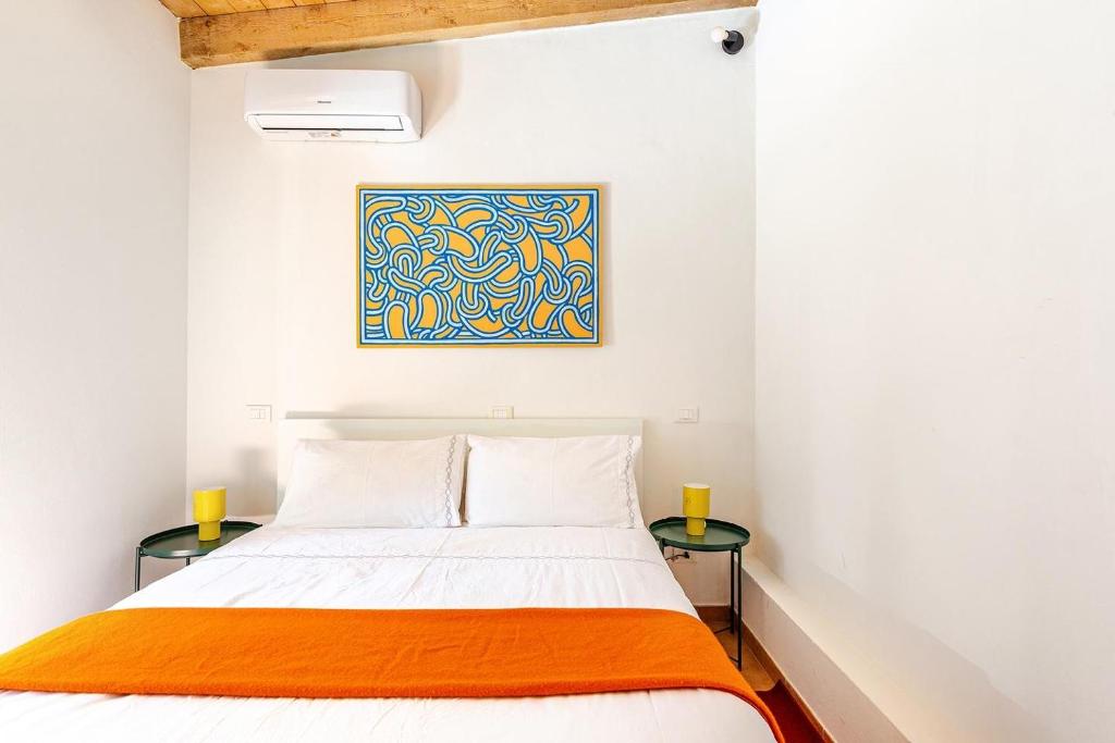 a bedroom with a bed and two tables at Dimora Farnese in Piacenza