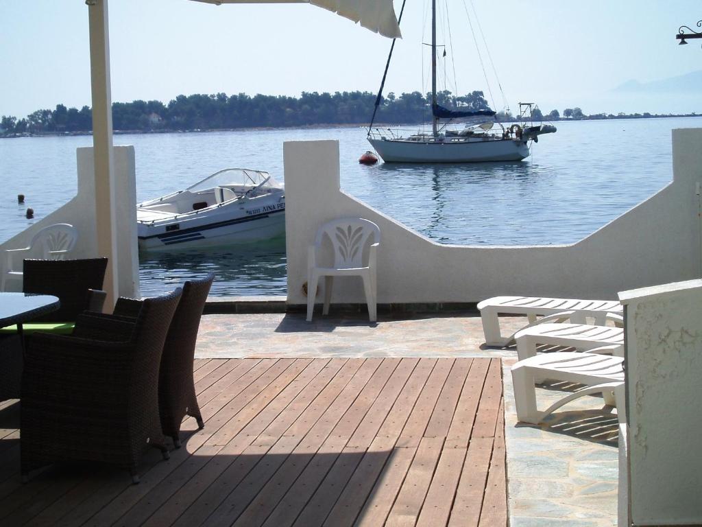 a boat in the water with a table and chairs at Villa Belmar Self-Catered Apartments in Eretria