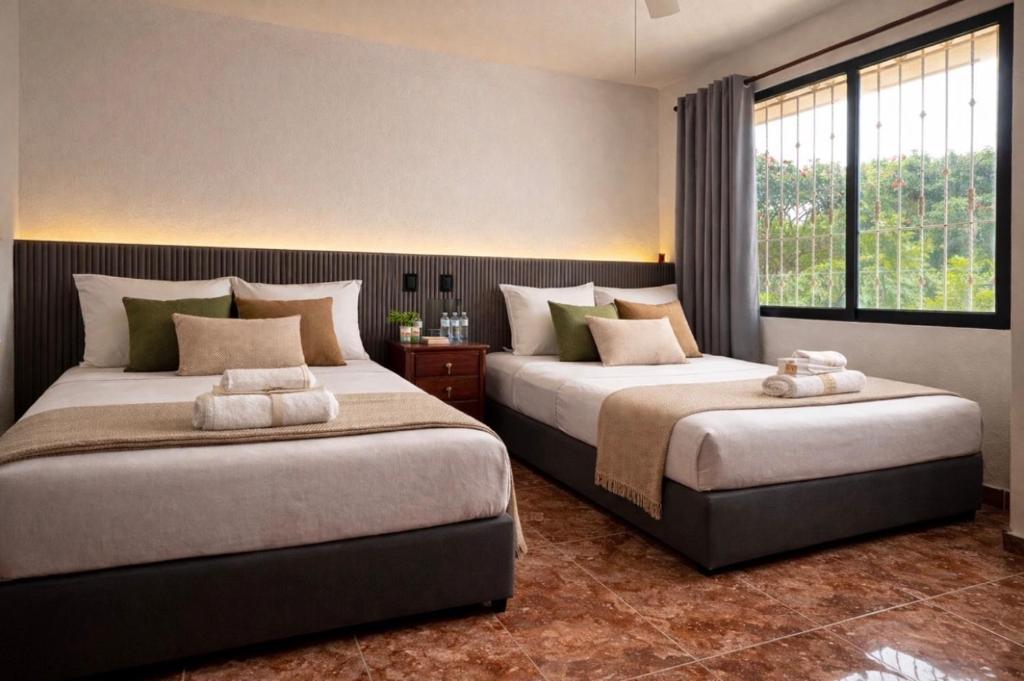 a bedroom with two beds and a window at Casa Solar Boutique Eco-Hotel in Minatitlán