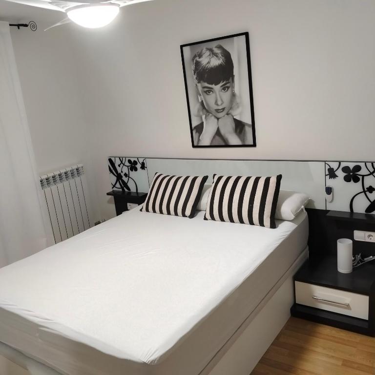 a white bed with a black and white pillow on it at Las heras apartamento in Medrano