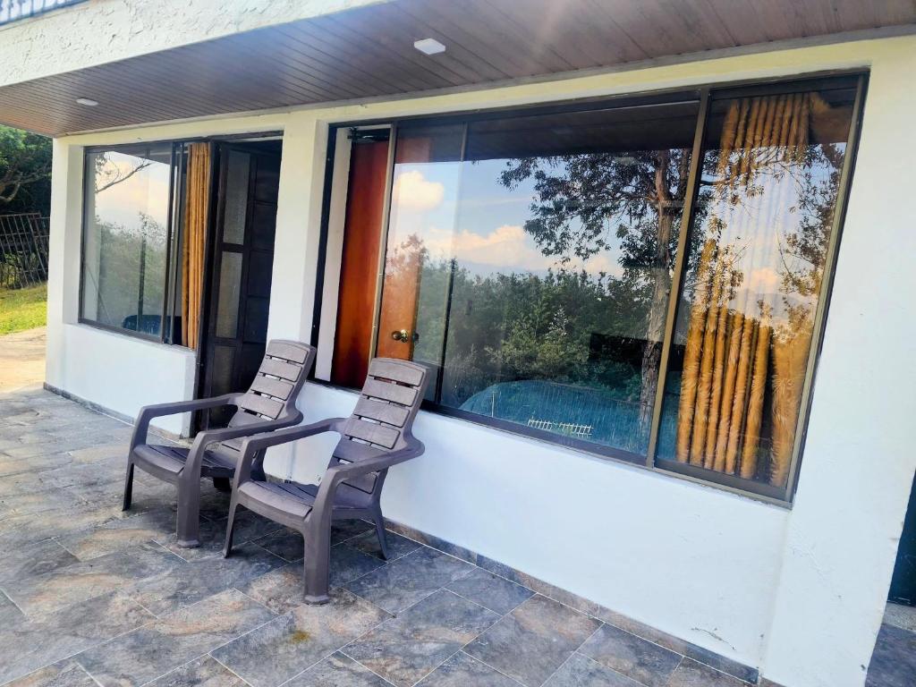 two chairs sitting on the porch of a house at Volterra Guatavita in Guatavita