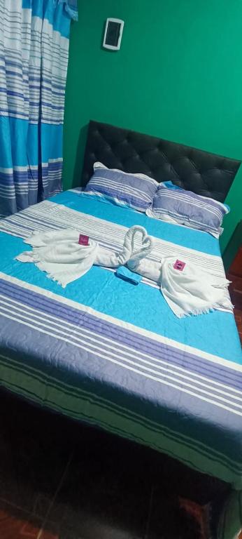 a bed with blue sheets and white towels on it at Apart Fiambala alojamiento in Fiambalá