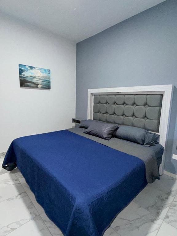 a bedroom with a large bed with a blue blanket at los agaves lto in Loreto
