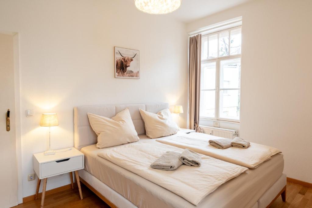 a bedroom with a large white bed with a window at Stadtvilla Alpenliebe in Bad Reichenhall