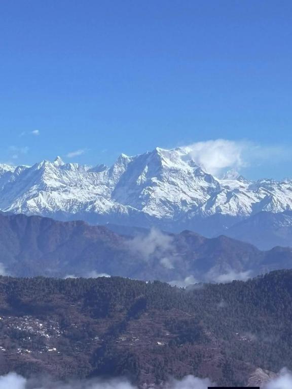 a view of a mountain range with snow covered mountains at Chill with pahadi in Lansdowne