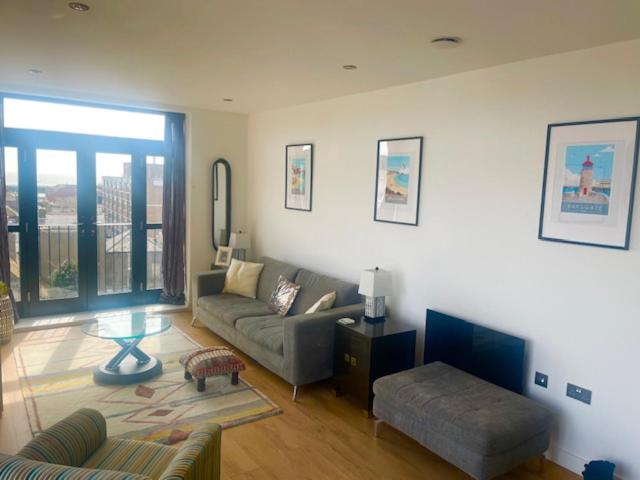 a living room with a couch and a table at Top-end penthouse with sea views and free parking in Ramsgate