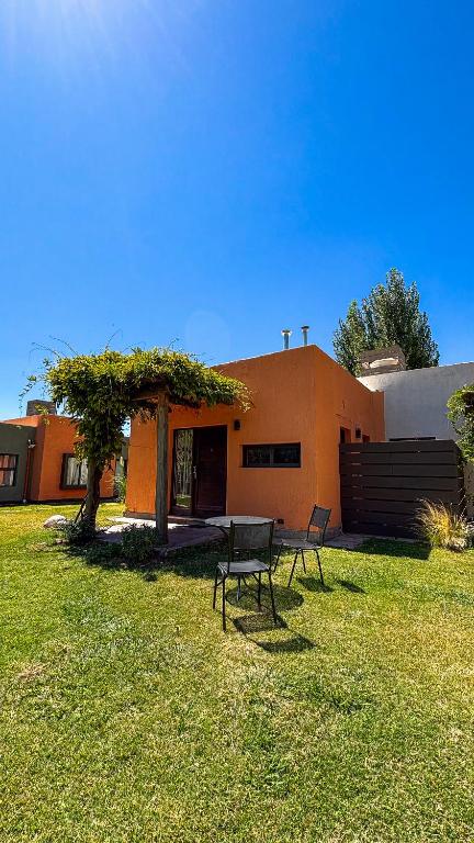 a house with a table and a bench in the yard at Comarca Andina in Ciudad Lujan de Cuyo