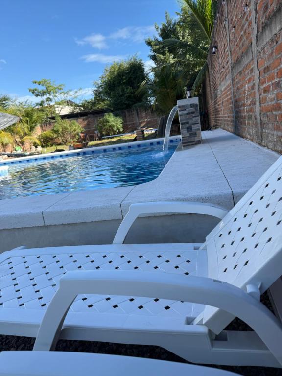 a white bench sitting next to a swimming pool at Rivera Solea in Llano de Los Patos