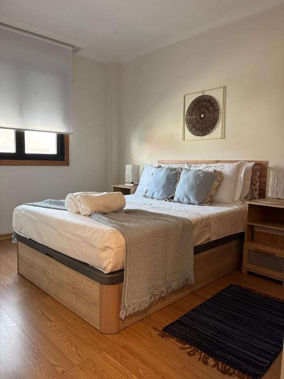 a bedroom with a large bed with blue pillows at Ponte da Illa in Isla de Arosa