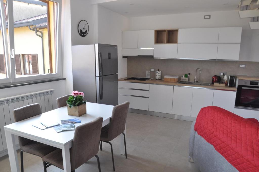 a kitchen with a table and chairs and a refrigerator at Il Borgo in Lurago D'Erba 