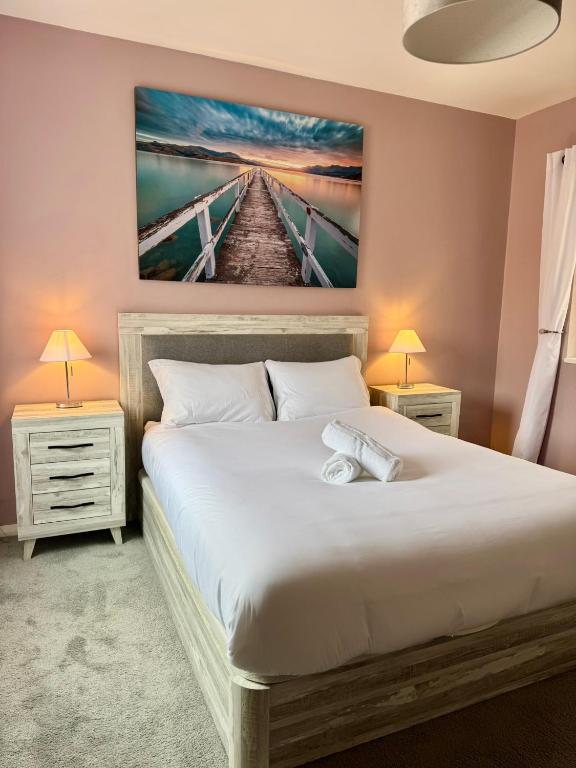 a bedroom with a large white bed with two night stands at Europa Point Area Townhouse in Gibraltar
