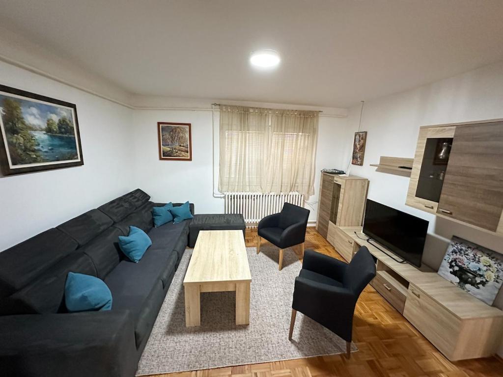 a living room with a black couch and a table at Villa Igman in Hrasnica