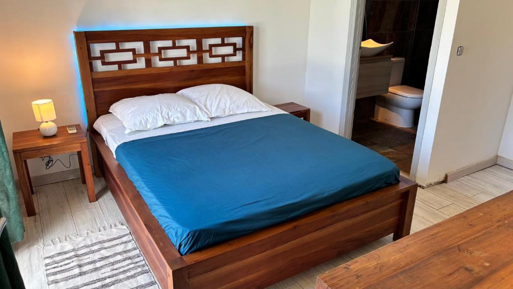 a bedroom with a bed with a blue mattress at Tropical Suite Direct Pool Access & Garden View in Baie-Mahault